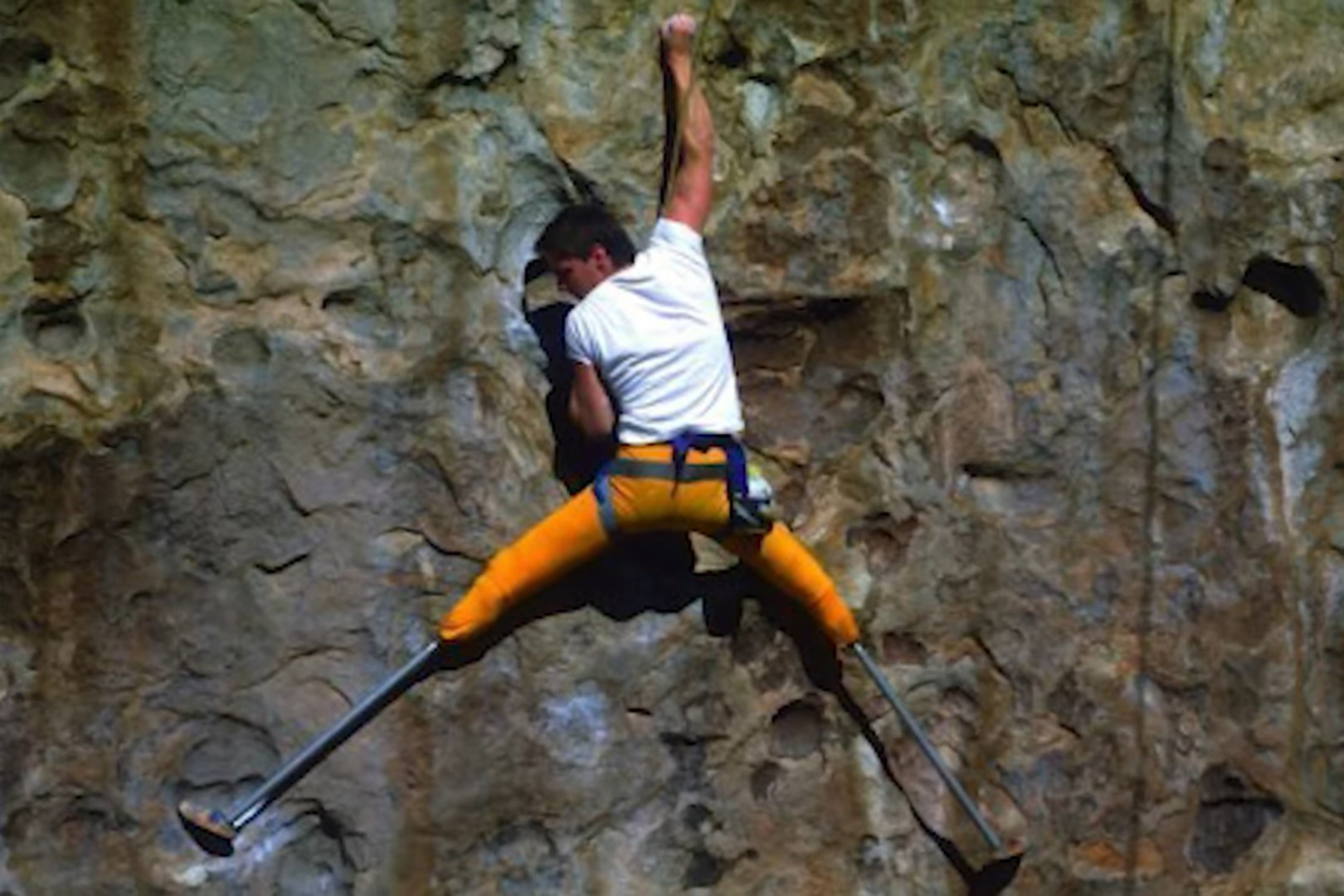A man with prosthetic legs climbing a rock wall